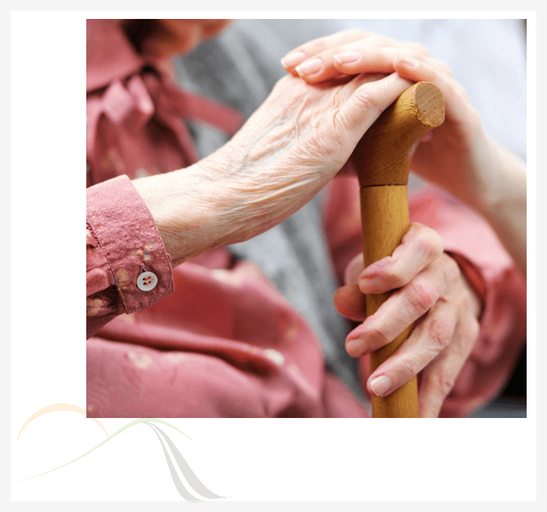A person holding onto a cane with their hands.